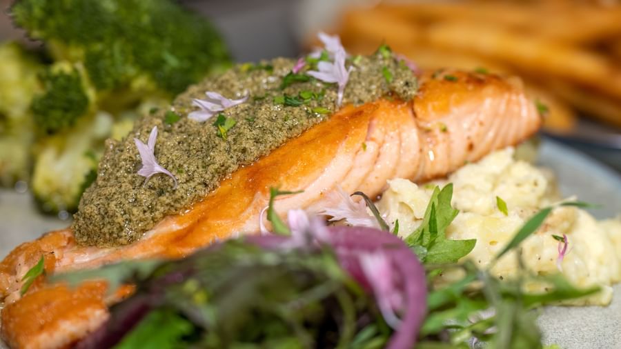 Grilled salmon fillet served with mashed potatoes, broccoli, and fresh greens at Narrow Gauge Inn.