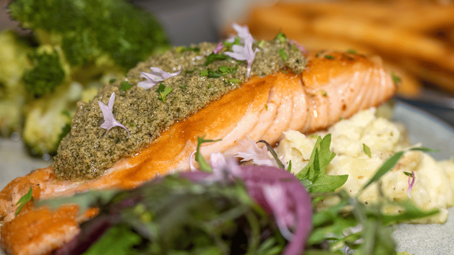 Grilled salmon fillet served with mashed potatoes, broccoli, and fresh greens at Narrow Gauge Inn.