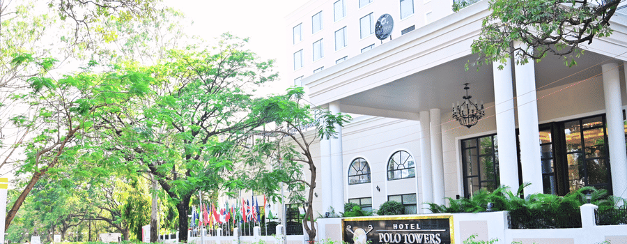 Facade view of the entrance to Polo Hotel Agartala with trees in the foreground