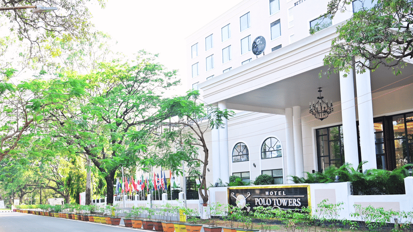 Facade view of the entrance to Polo Hotel Agartala with trees in the foreground