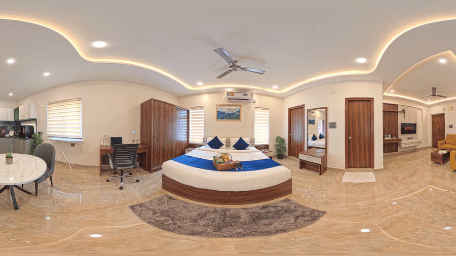 A 360-degree panorama shows a room with a round bed, a table, and ceiling lights at Elysium Studio Suites, Madhapur.