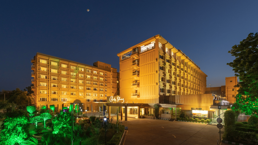 Facade of Clarks Shiraz, Agra, a hotel in Agra for family, with multiple floors illuminated at night with lights