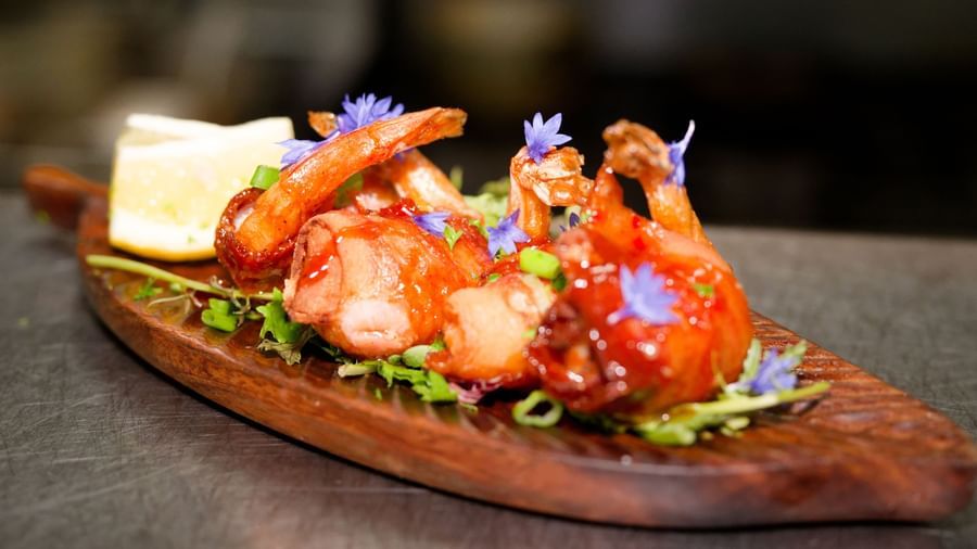 Grilled shrimp served on a wooden platter with salad and lemon at Narrow Gauge Inn.