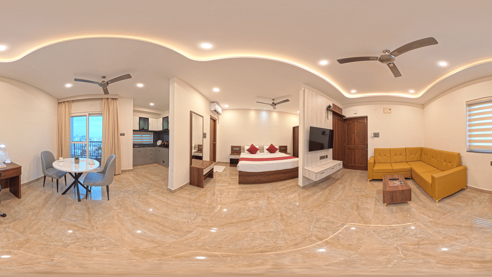 A 360-degree panorama shows a room with a bed, yellow sofa, and desk under ceiling lights at Elysium Studio Suites, Madhapur.