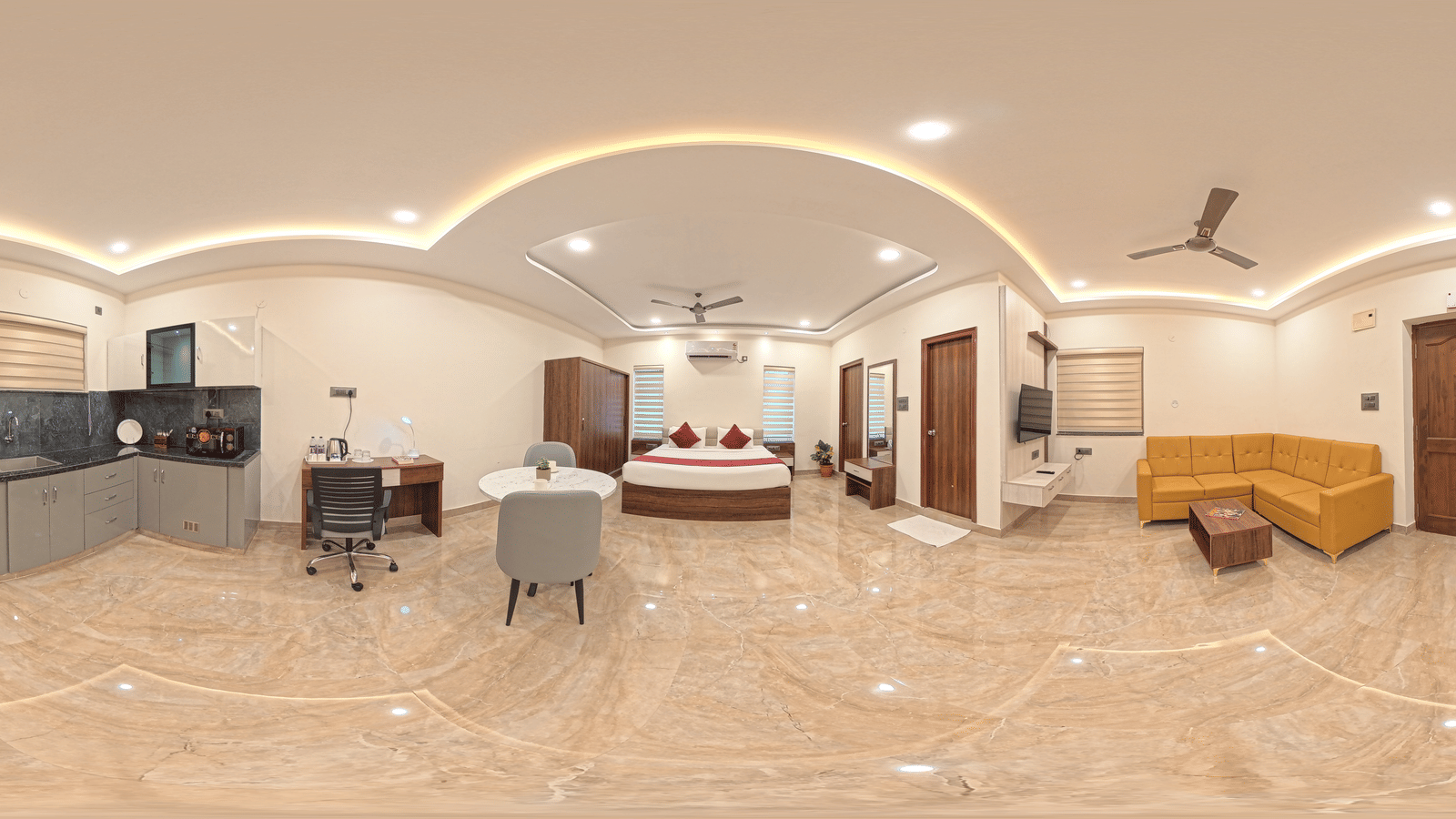 A 360-degree panorama shows a room with a bed, a desk, and a television fixed to the wall at Elysium Studio Suites, Madhapur.