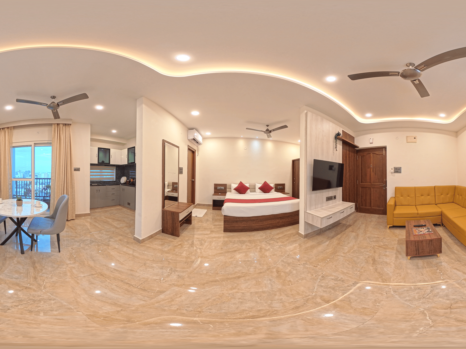 A 360-degree panorama shows a room with a bed, yellow sofa, and desk under ceiling lights at Elysium Studio Suites, Madhapur.