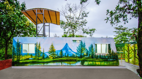 Container-style unit with mural art, trees, and red tiled path in the garden area at Nature Trails Durshet.