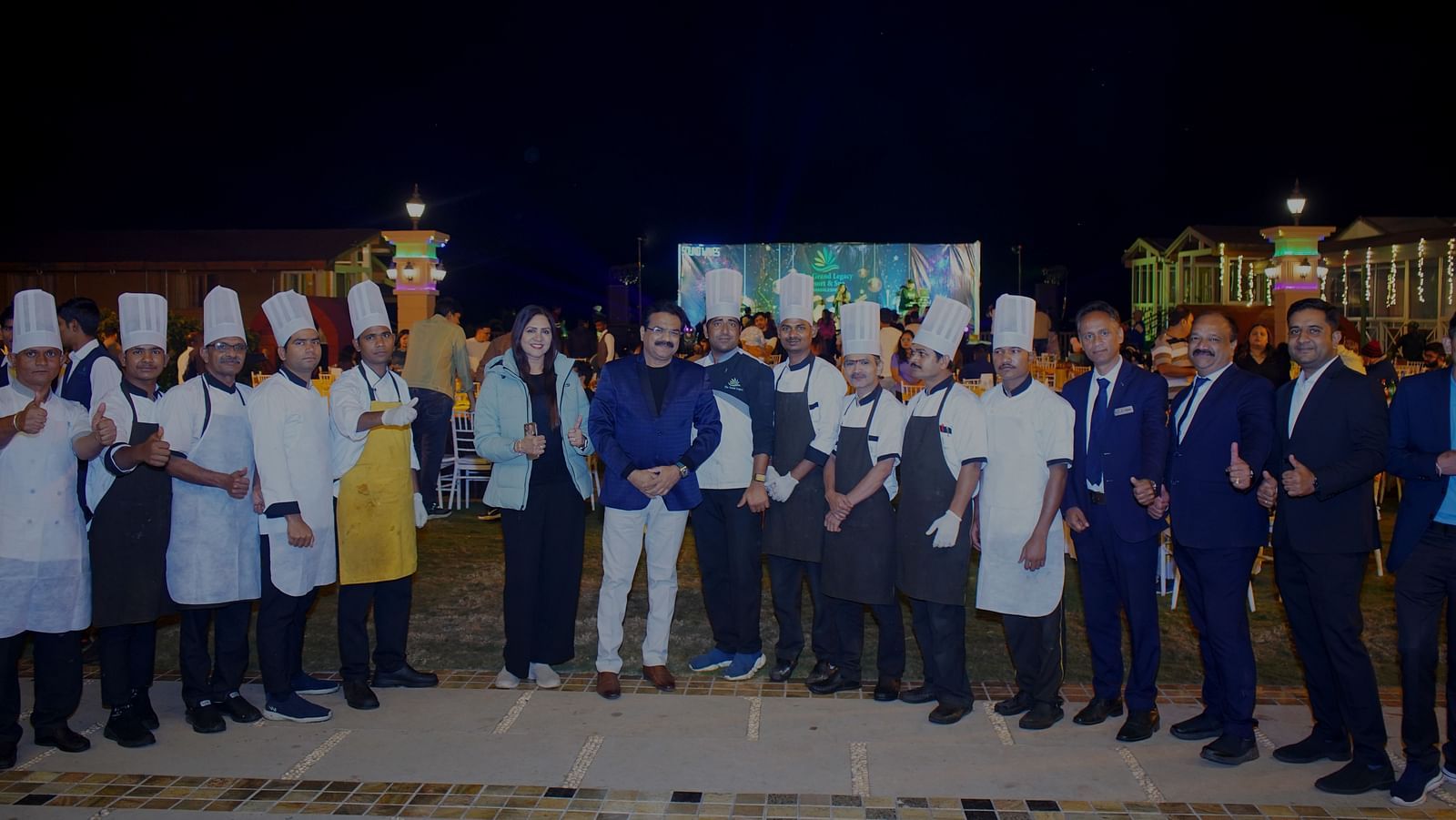 Staff and chefs standing together for a team photo at an outdoor venue - The Grand Legacy Resort & Spa
