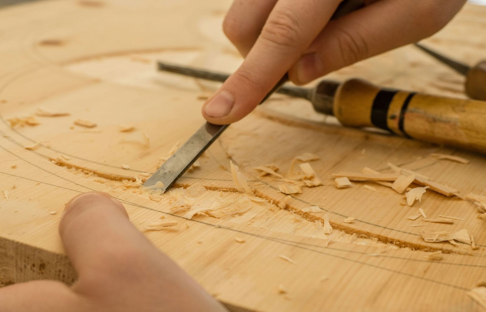 A close up shot of a man carving wood