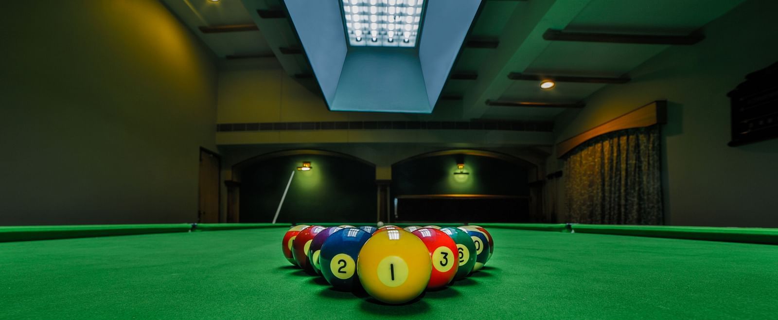 Pool table with billiards ball placed on the table at Tara, Comfort Hotel in Hyderabad - Ramoji Film City.