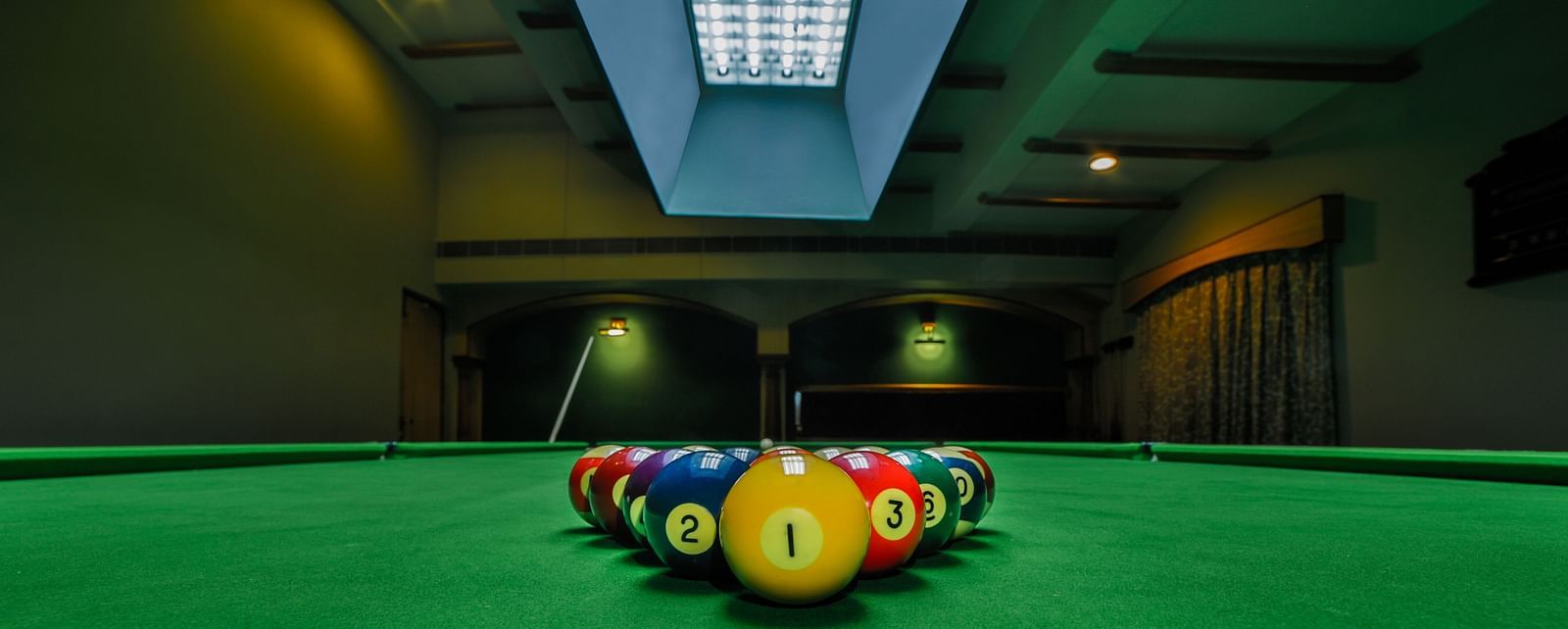 Pool table with billiards ball placed on the table at Tara, Comfort Hotel in Hyderabad - Ramoji Film City.