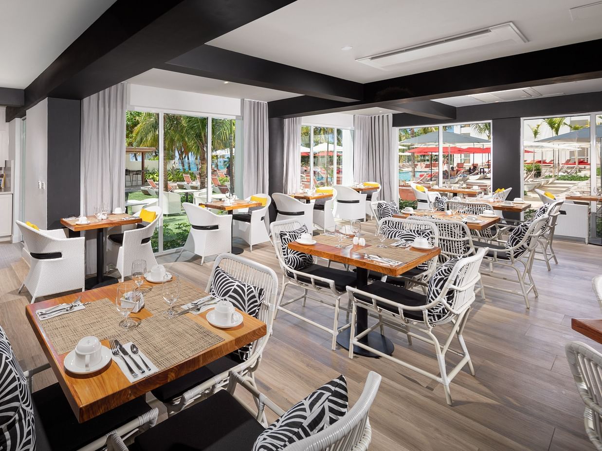 A fine-dining setup of a restaurant with stylish chairs, wooden tables and wooden flooring adding to the ambience - S Hotel Montego Bay, Jamaica