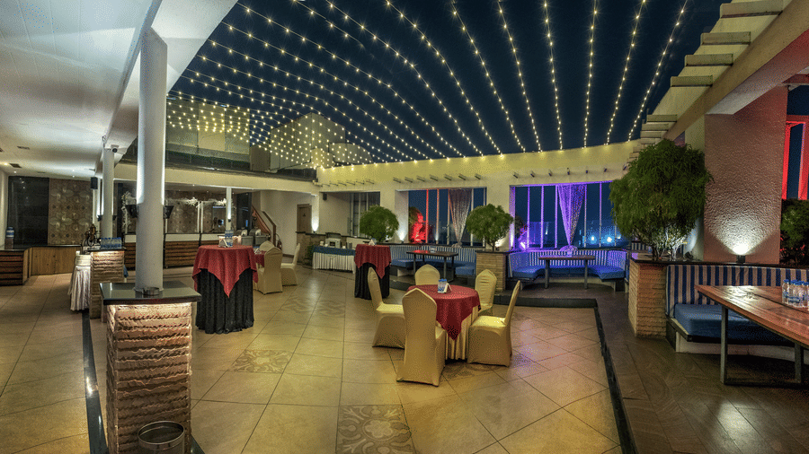 Chic outdoor dining and lounge area with illuminated ceiling at The Sonnet, Jamshedpur.
