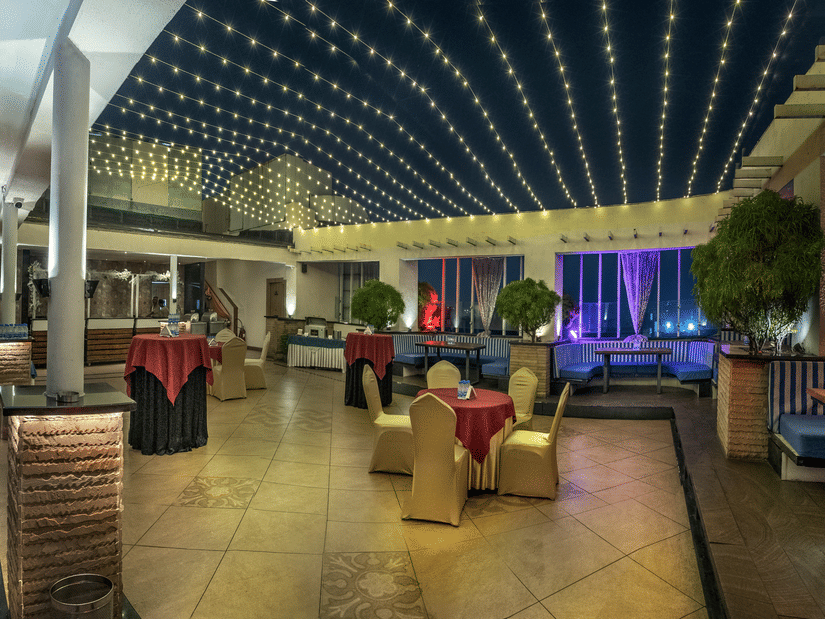 Chic outdoor dining and lounge area with illuminated ceiling at The Sonnet, Jamshedpur.