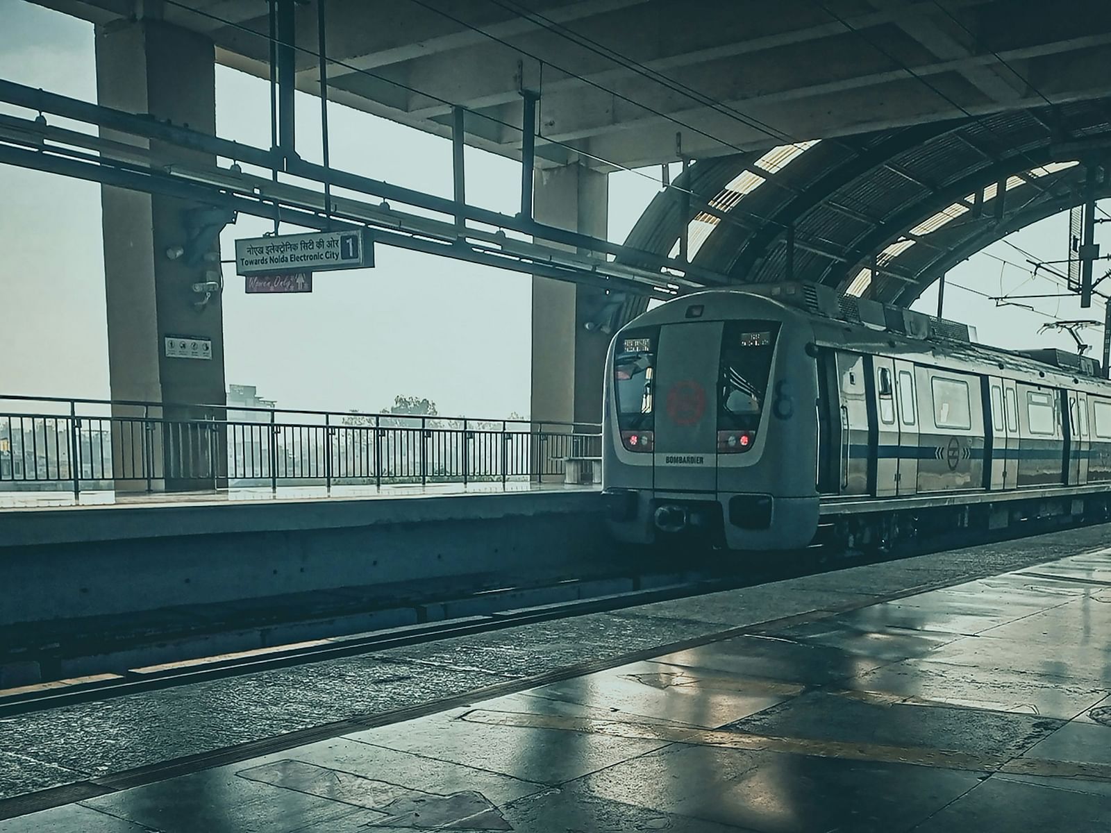 An overview of an empty metro station with a train arriving to the station.