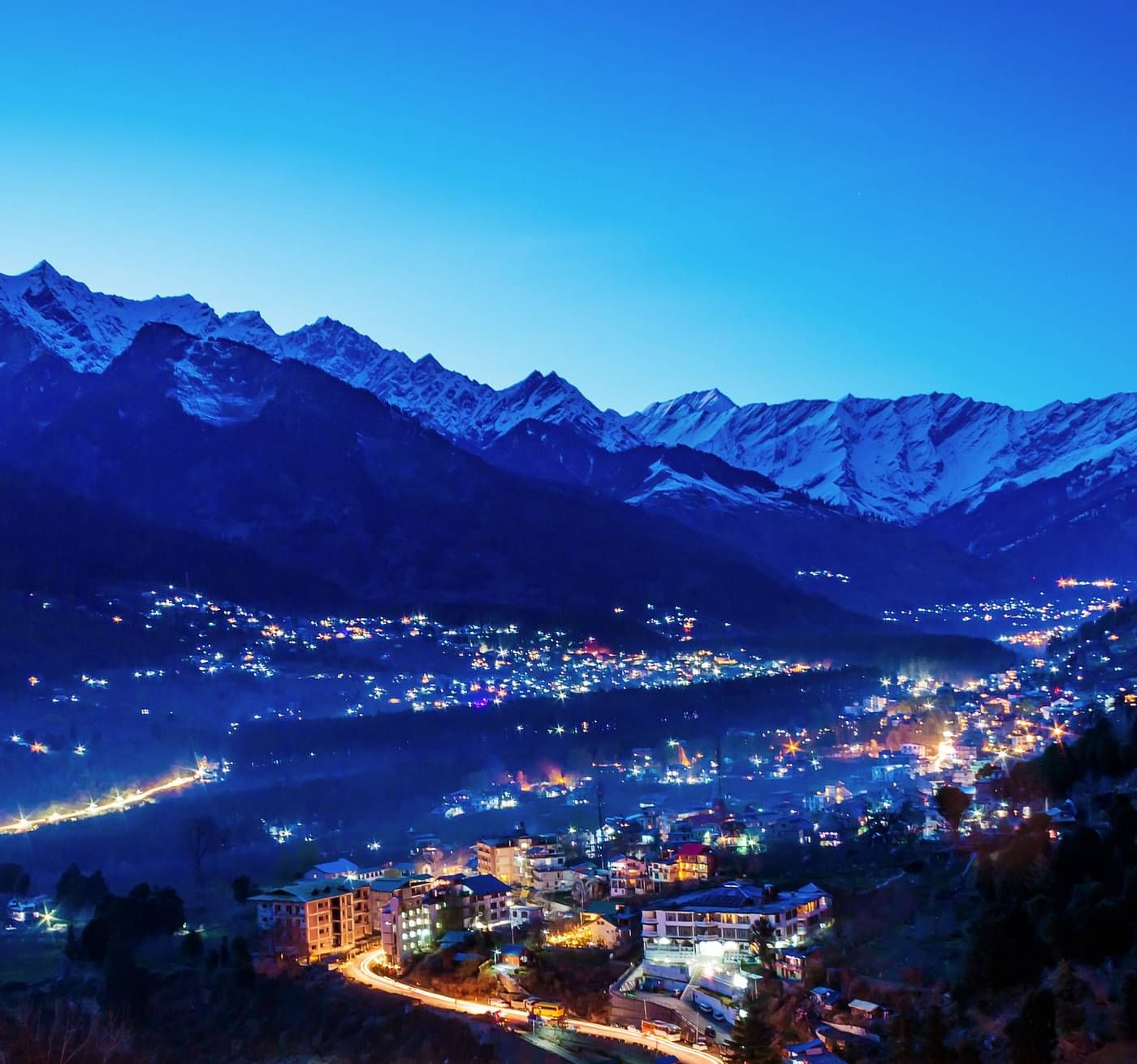 a view of himachal on a late eveing with small lights of the city