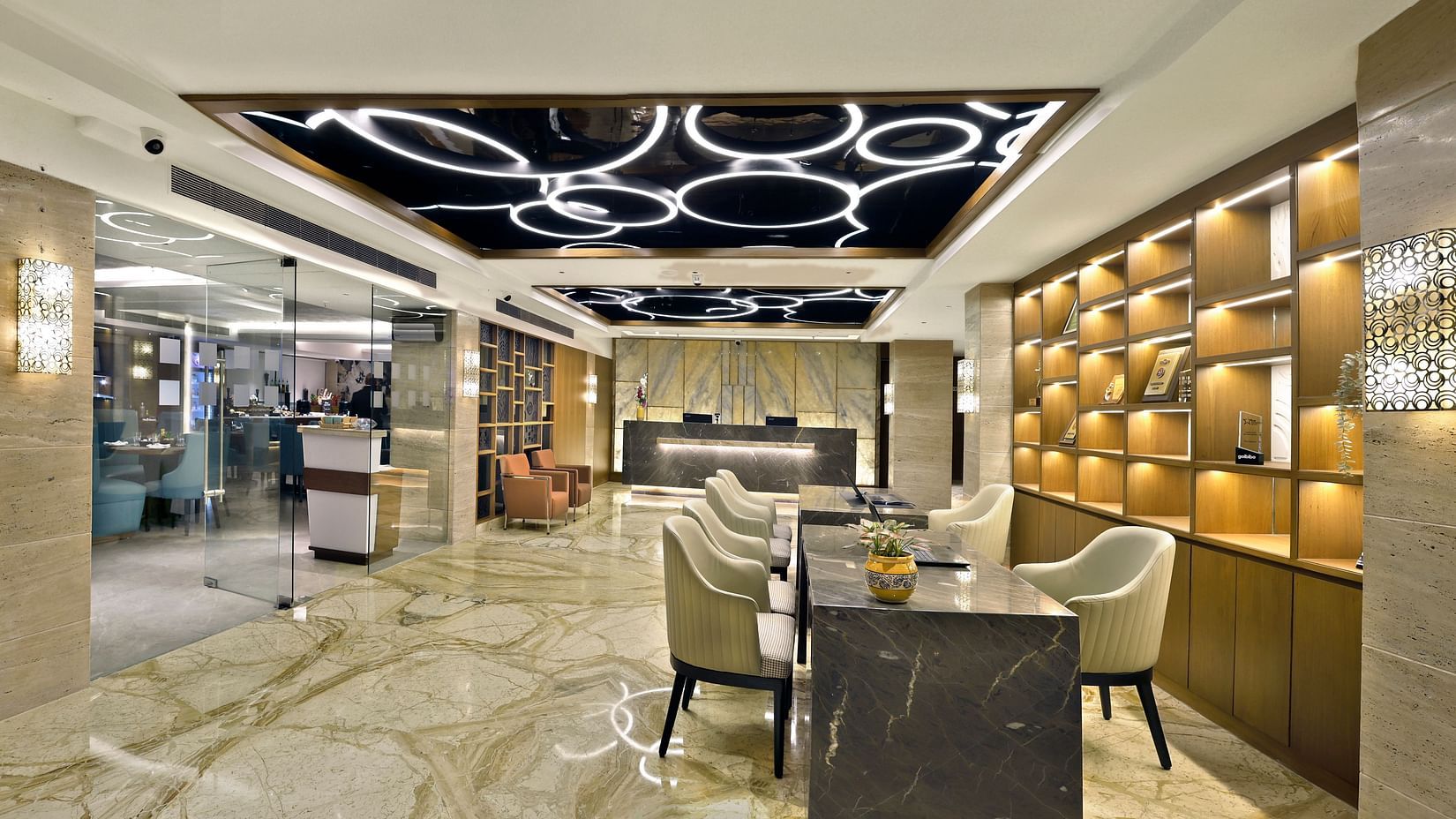 A hotel lobby with a reception desk, seating area, and decorative wall feature.- The Sonnet, Kolkata