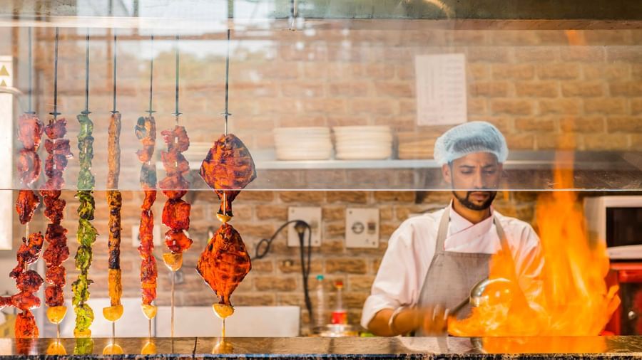 A chef preparing food over a grill at The Citi Residenci Hotel, Durgapur.