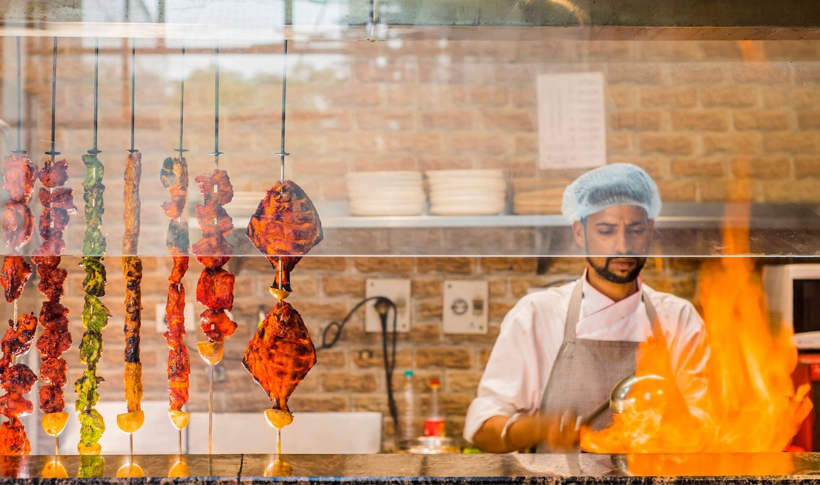A chef preparing food over a grill at The Citi Residenci Hotel, Durgapur.