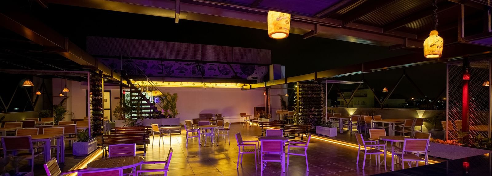 Image of  a dimly lit dining space with tables and chairs at M Pro Palace.