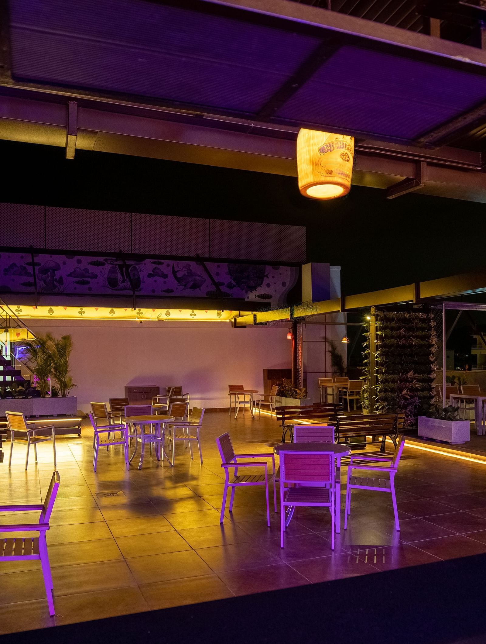 Image of  a dimly lit dining space with tables and chairs at M Pro Palace.