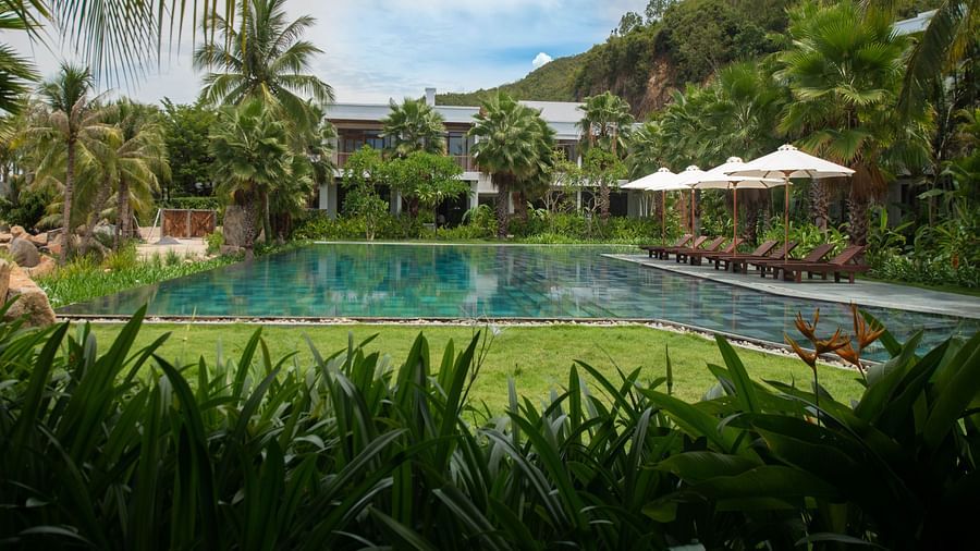 A garden side view of the pool at our resort on a bright sunny day - Alibu Resort Nha trang