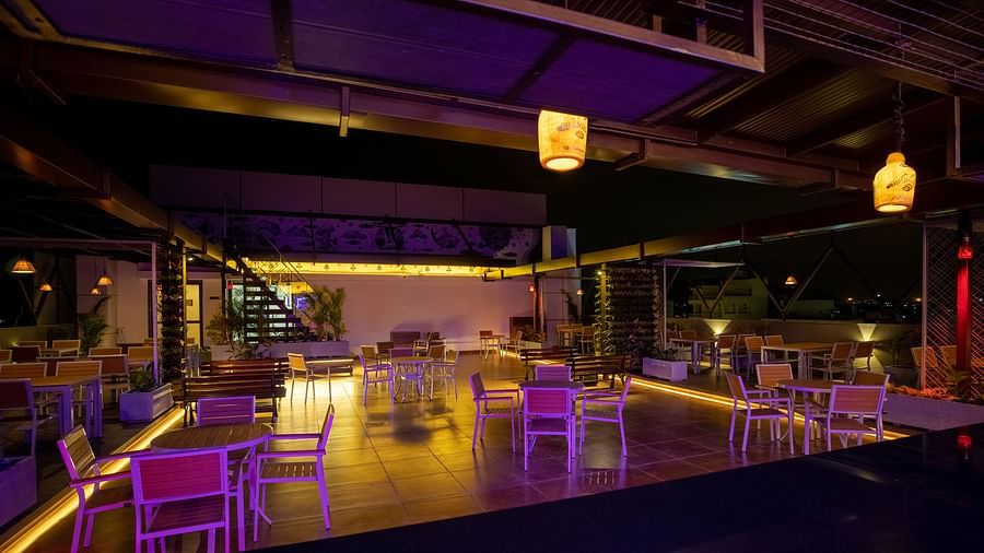 Image of  a dimly lit dining space with tables and chairs at M Pro Palace.