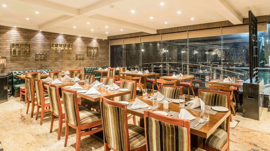 Elegant hotel restaurant with neatly set tables and chairs, ready for diners | The Citi Residenci Hotel Durgapur