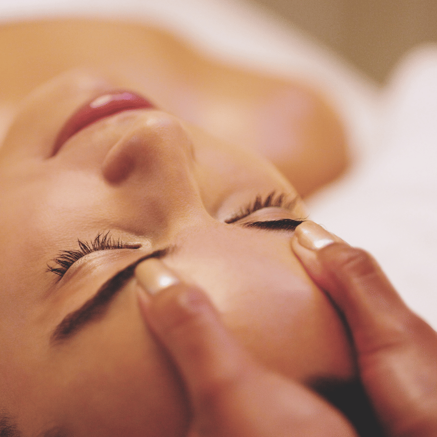 Client enjoying a facial massage with closed eyes.