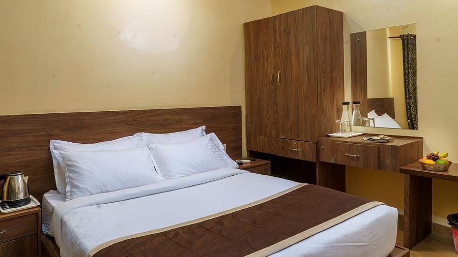 Standard Room with bed and dressing table at Wyt Hotels, Rameswaram 