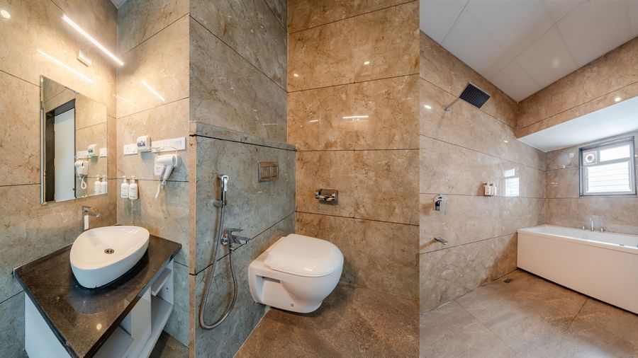 Modern bathroom with a sleek vanity, toilet, and bathtub | Suite | Pravasa Hotel, Vijayapura
