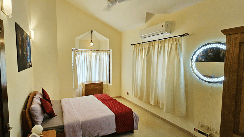 Full-view shot of a bedroom featuring a double bed with a sloppy ceiling above it at Amara Villa, Nagoa.