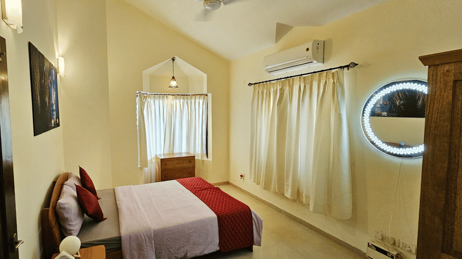 Full-view shot of a bedroom featuring a double bed with a sloppy ceiling above it at Amara Villa, Nagoa.