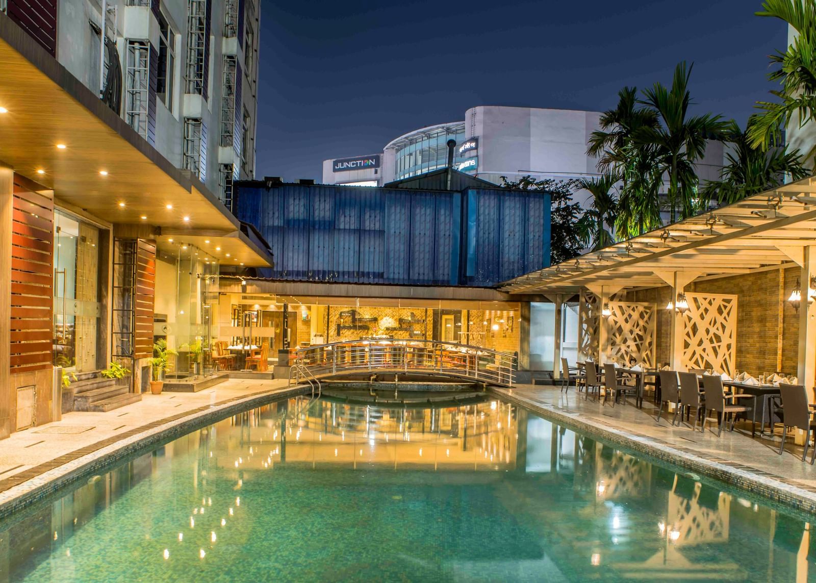 Hotel swimming pool at night surrounded by lounge chairs and illuminated by artificial lights | The Citi Residenci Hotel Durgapur