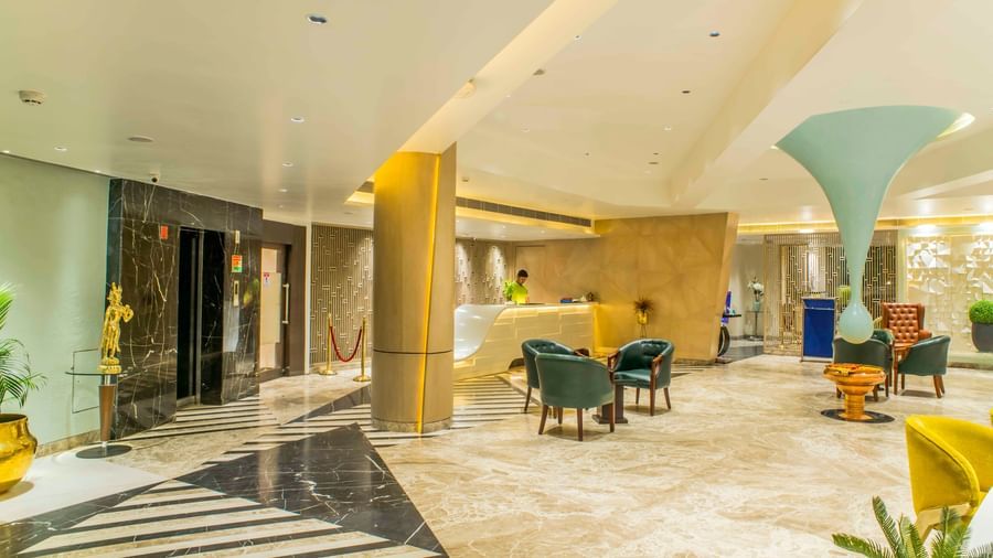 Spacious hotel lobby featuring contemporary seating, a curved reception desk, and artistic lighting| The Citi Residenci Hotel Durgapur