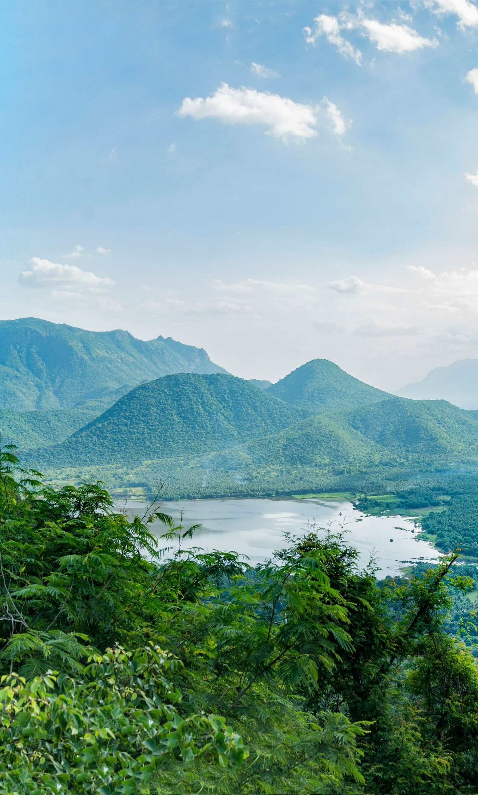 An image of lush green hills with a lake in between