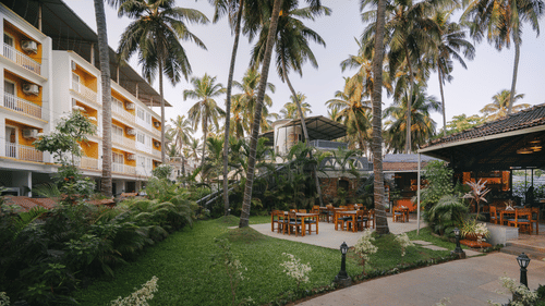 Lush green garden at Richmonde Ananta Elite, Goa with a peaceful atmosphere and outdoor seating amidst scenic surroundings.