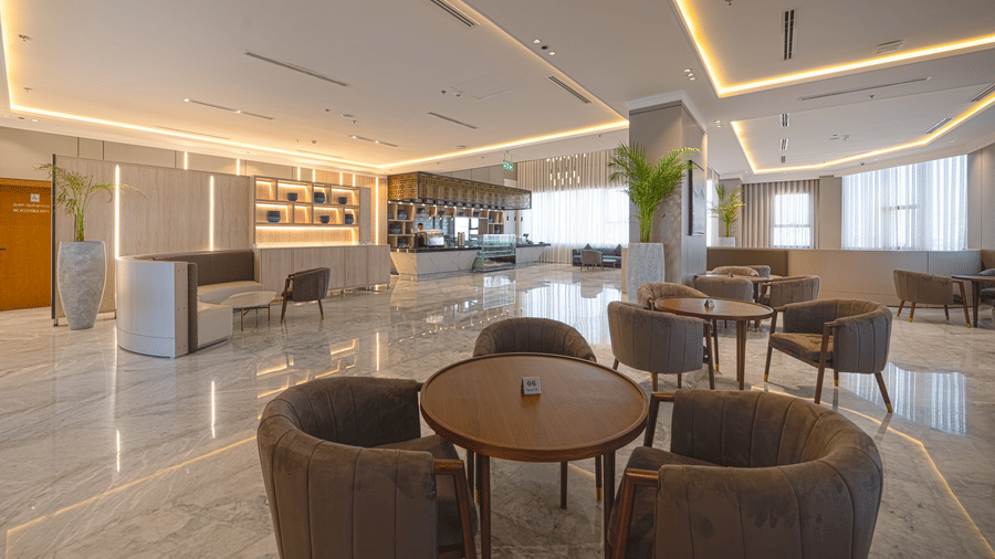 Grand Iva Cafe at Grand Iva Hotel, Abha, seen with upholstered seating, large glass windows letting in natural light, and modern decor.