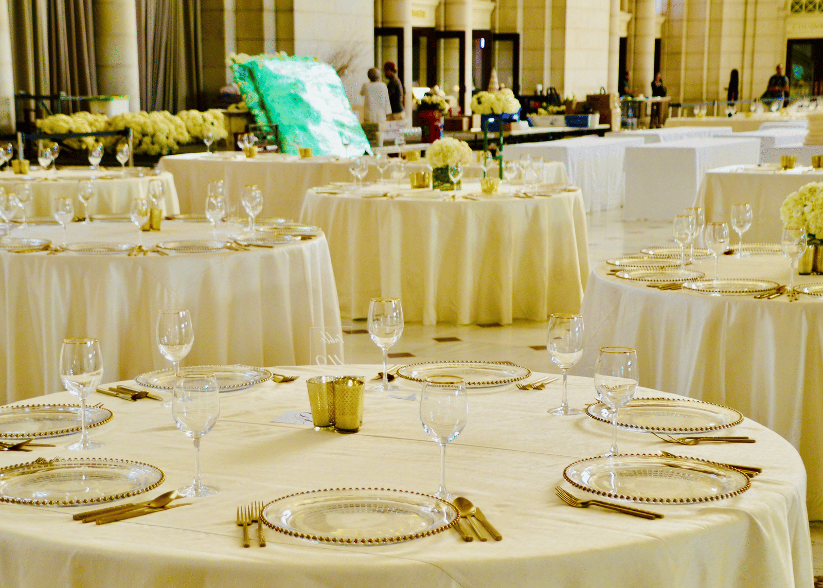 Elegant banquet setup with ivory drapes and glassware, perfect for weddings and grand celebrations.