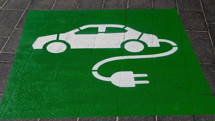 An electric vehicle charging point sign painted on the road