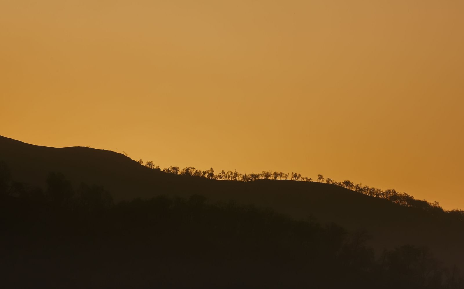 A silhouette of a mountain at sunset