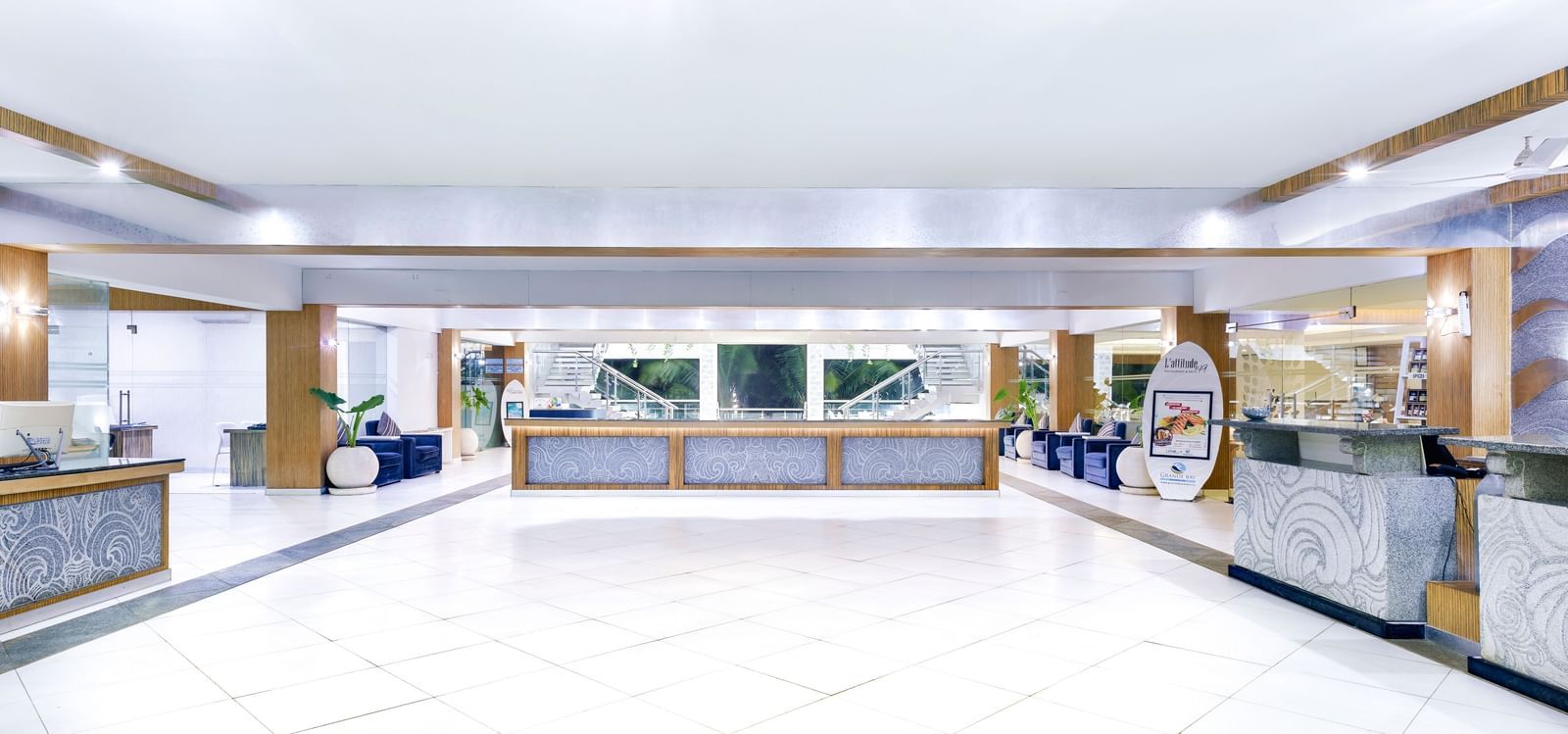 A bright, spacious hotel lobby with a long reception desk and ample seating | Grand Bay Resort and Spa