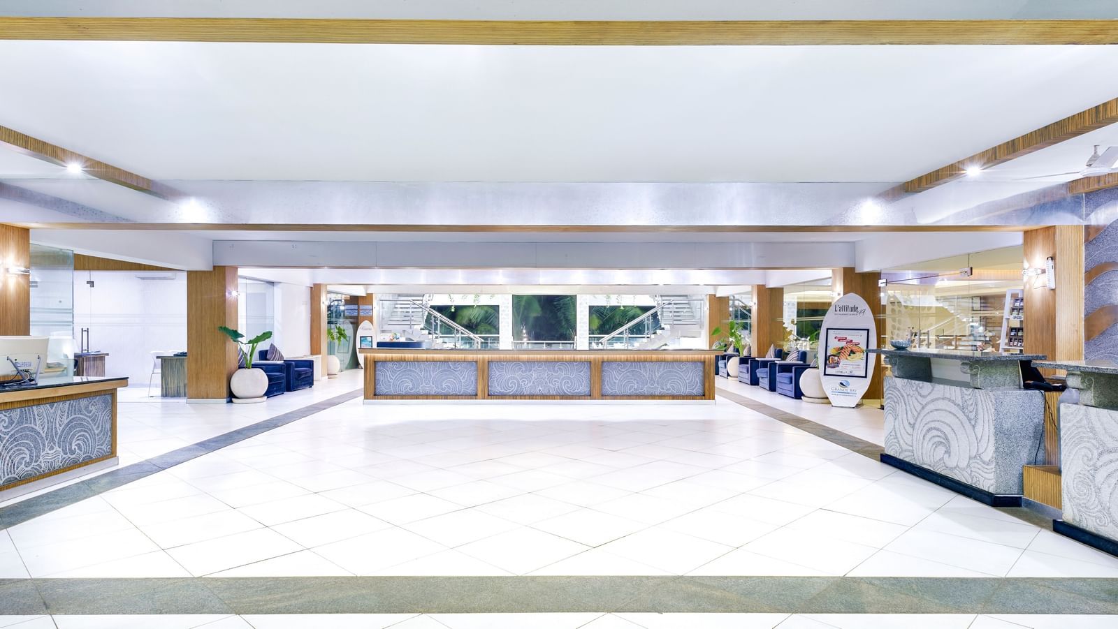 A bright, spacious hotel lobby with a long reception desk and ample seating | Grand Bay Resort and Spa