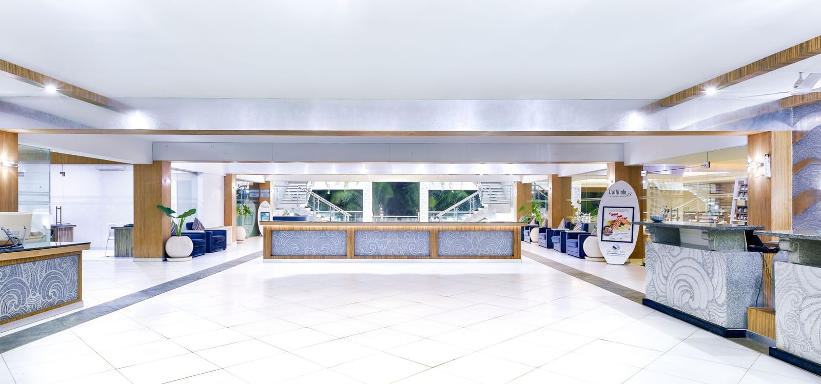 A bright, spacious hotel lobby with a long reception desk and ample seating | Grand Bay Resort and Spa