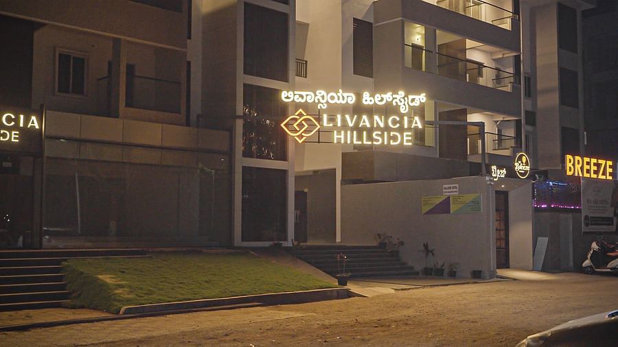 Closer view of the hotel entrance at night with illuminated signage and stairs leading up at TGI Livancia Hillside, JC Nagar, Mysore
