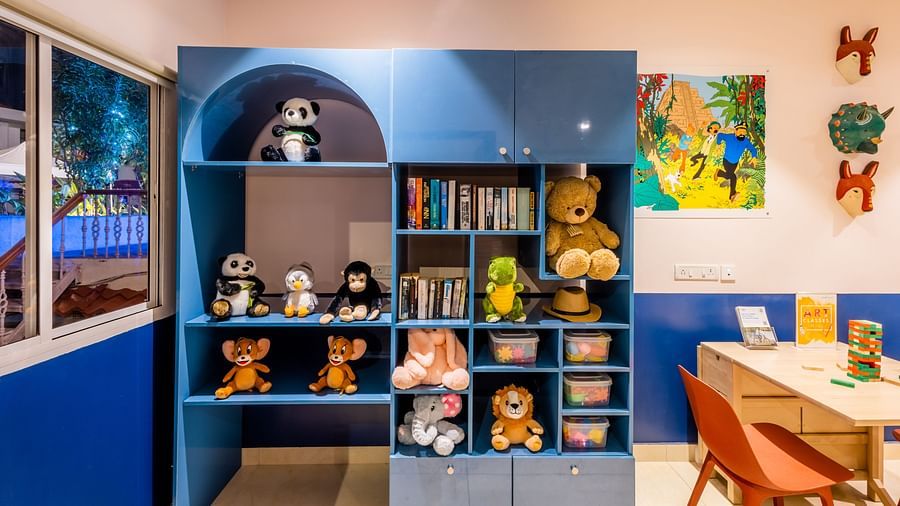 Dolls and books kept in a shelf at Rumpus - Heritage Village Resorts Spa Goa