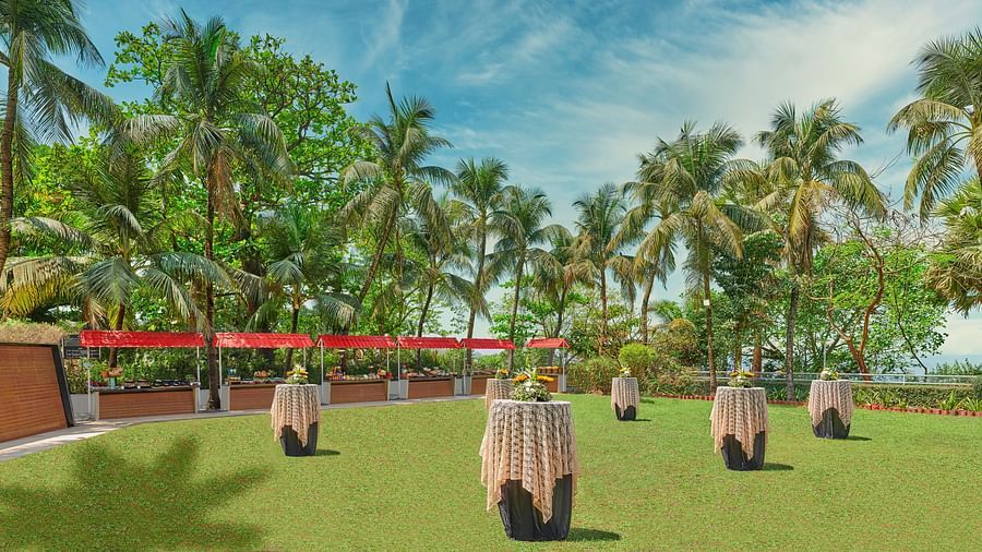 A wide view of a lawn with tables placed in it during the day | The Resort