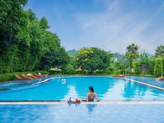 Awide view of the  lady relaxing by the swimming pool at Tattwaa.