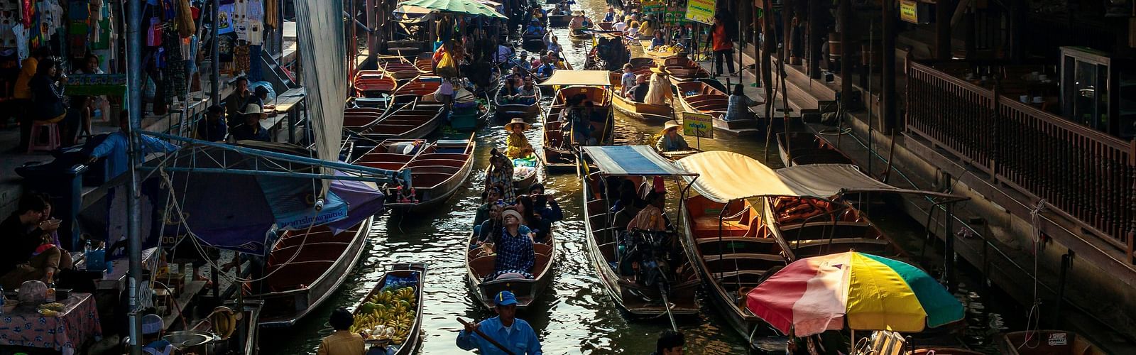 an overview of a floating market with different boats selling different things.