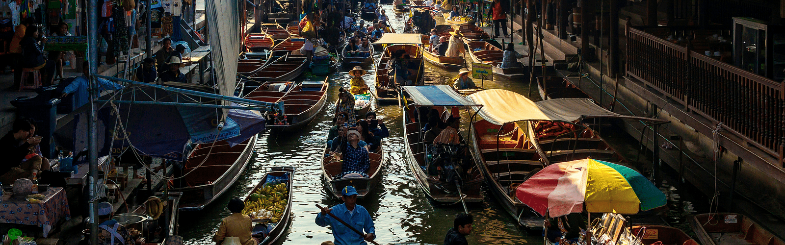 an overview of a floating market with different boats selling different things.